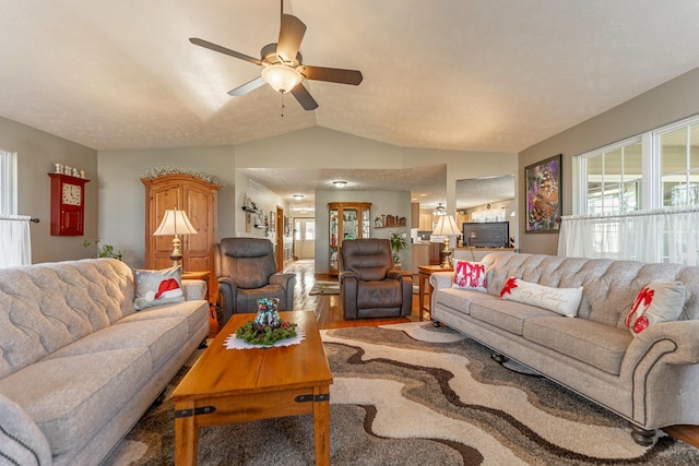 living area with lofted ceiling, ceiling fan, and wood finished floors