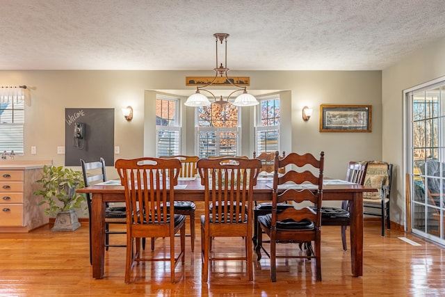 dining space featuring a textured ceiling and light wood-style floors