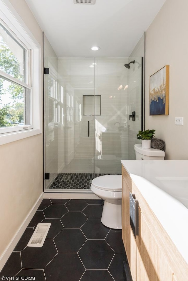 bathroom with visible vents, vanity, a shower stall, and toilet