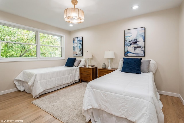 bedroom featuring light wood finished floors, baseboards, and recessed lighting