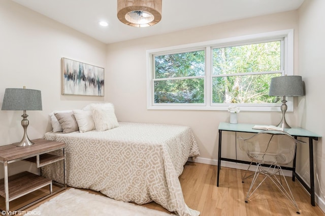 bedroom featuring baseboards, wood finished floors, and recessed lighting