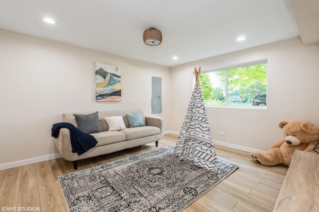 playroom with recessed lighting, electric panel, baseboards, and wood finished floors