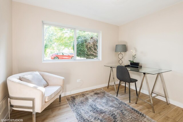 office space with light wood-type flooring and baseboards