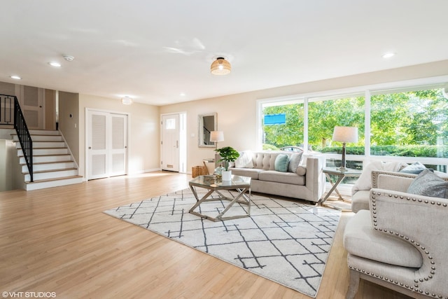 living room with recessed lighting, wood finished floors, and stairs