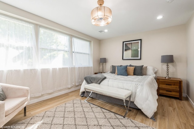 bedroom with recessed lighting, visible vents, baseboards, and wood finished floors