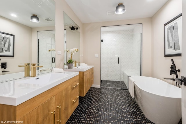 bathroom with a sink, a stall shower, and a freestanding tub