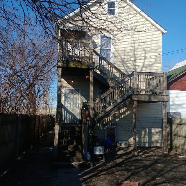 rear view of house with fence and stairway