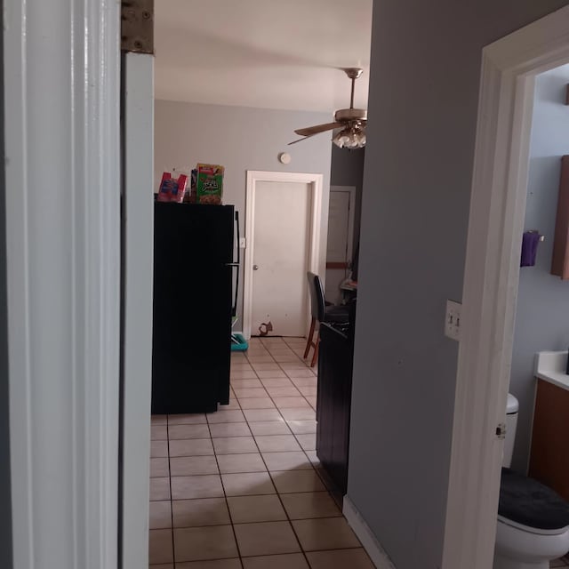 kitchen with light tile patterned floors, ceiling fan, and freestanding refrigerator