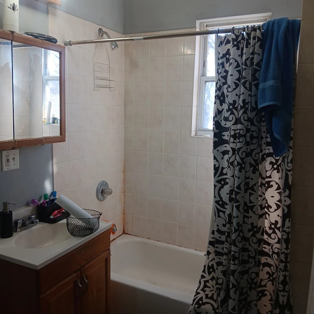 bathroom featuring shower / bath combo with shower curtain and vanity