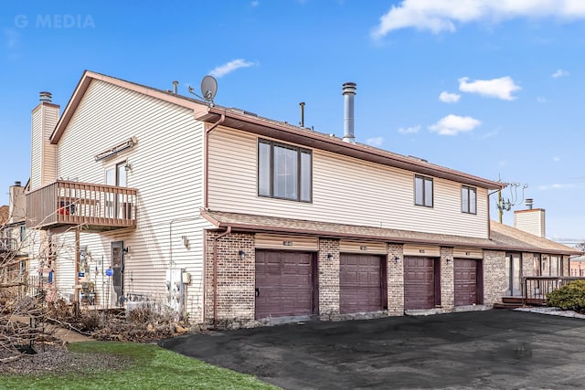 view of side of home featuring a garage and brick siding