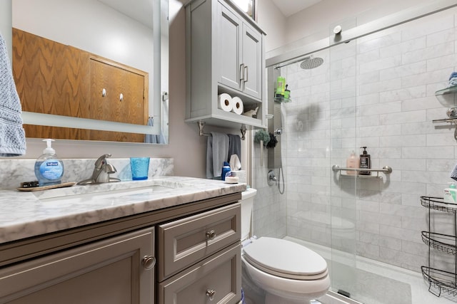 full bath featuring a stall shower, vanity, and toilet