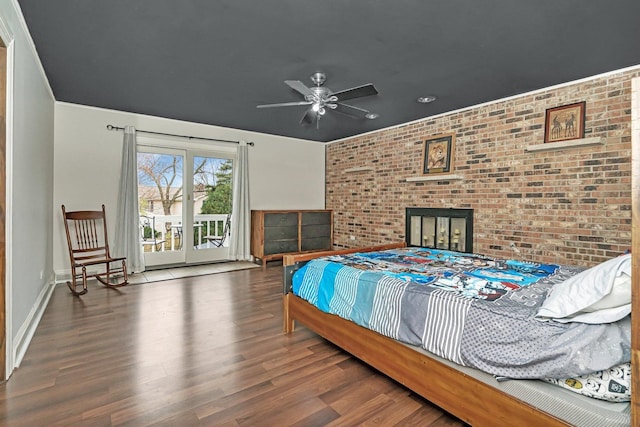 bedroom with access to exterior, ceiling fan, brick wall, wood finished floors, and baseboards