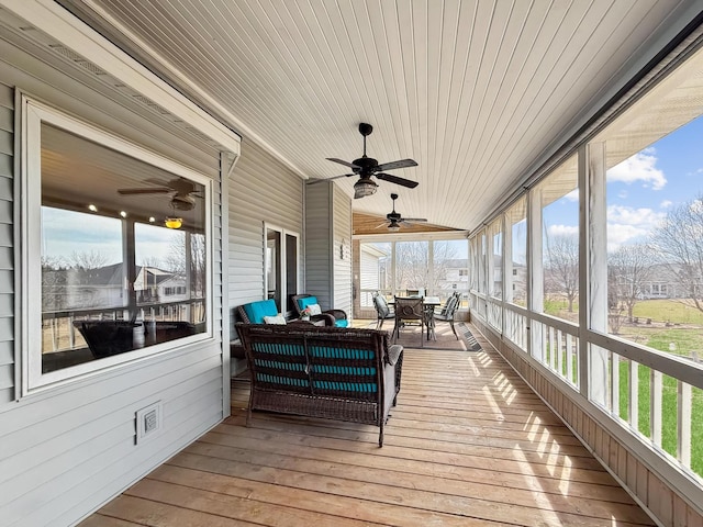 wooden terrace with outdoor dining area, an outdoor hangout area, and a ceiling fan