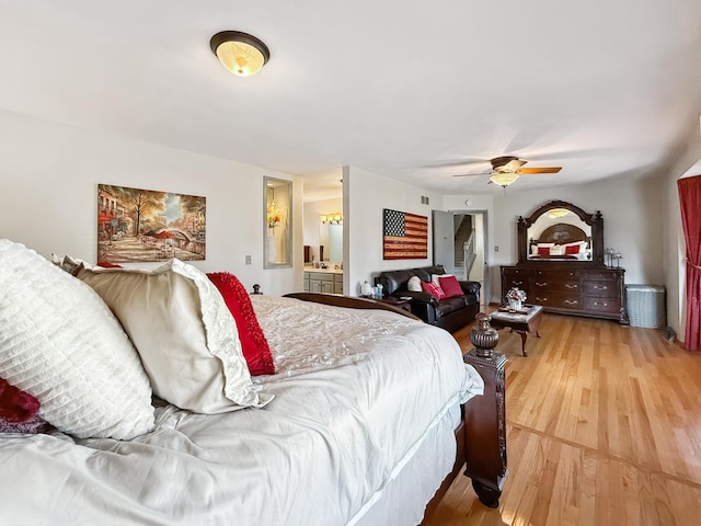 bedroom with ceiling fan, light wood finished floors, and ensuite bathroom