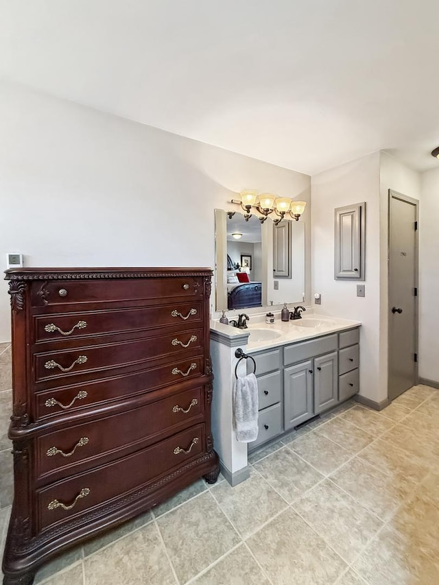 bathroom with double vanity, tile patterned flooring, baseboards, and a sink