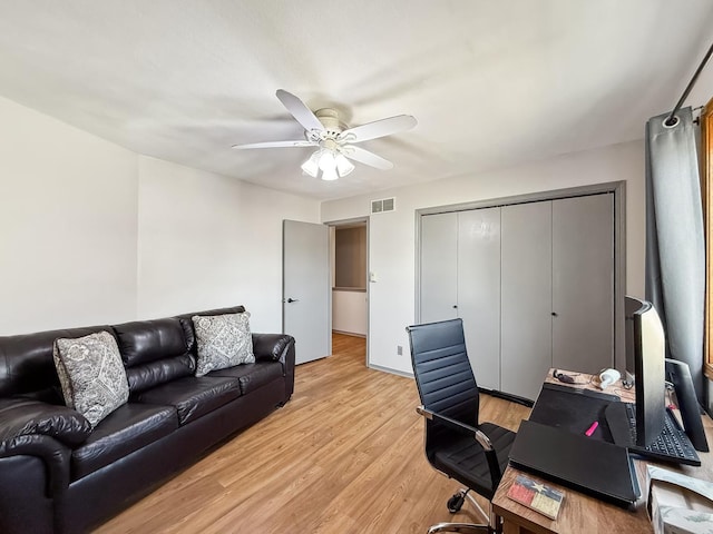 office area with light wood finished floors, visible vents, and a ceiling fan