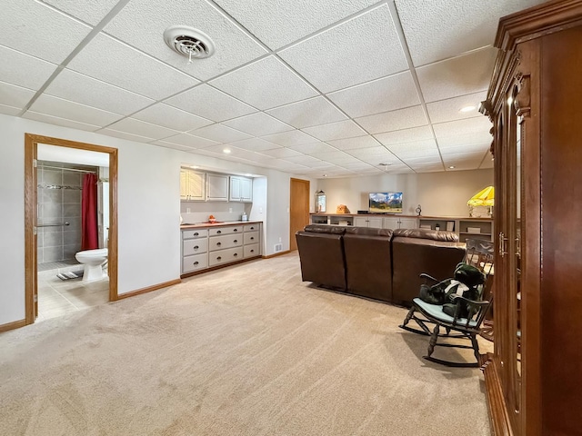 living room with light carpet, baseboards, visible vents, and a drop ceiling