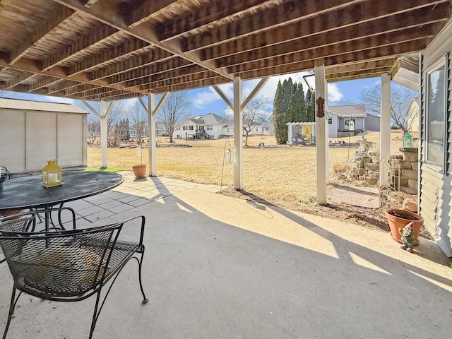 view of patio featuring an outbuilding, a shed, and a residential view