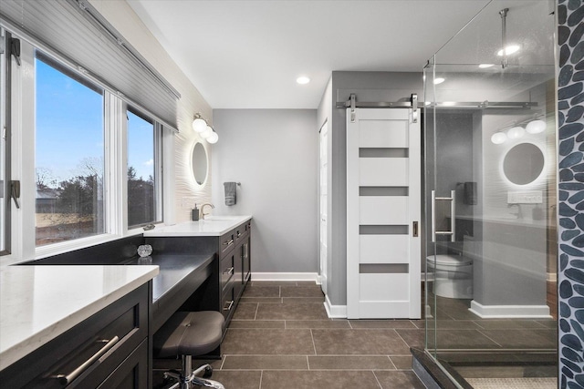 bathroom with baseboards, toilet, a stall shower, and vanity