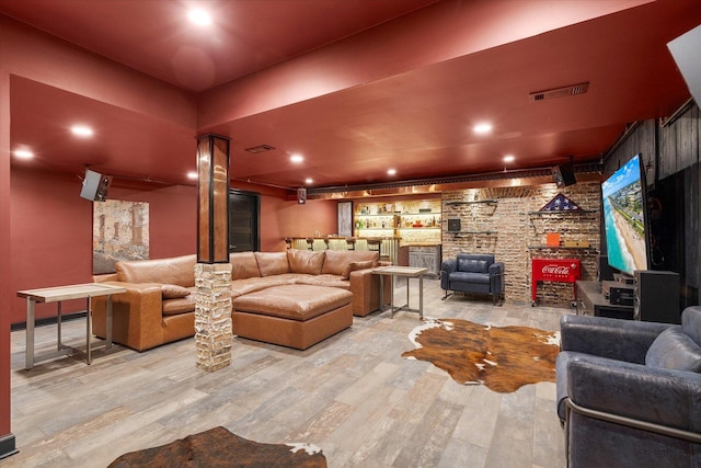 living area featuring visible vents, bar area, and wood finished floors