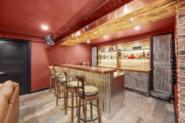 bar featuring light wood-type flooring and wet bar