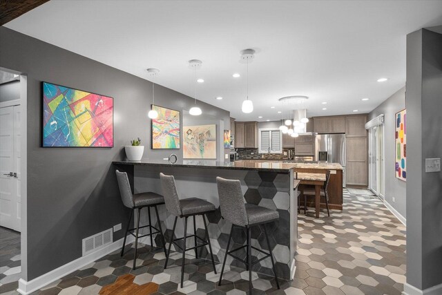 kitchen featuring tasteful backsplash, a center island, light floors, appliances with stainless steel finishes, and island exhaust hood