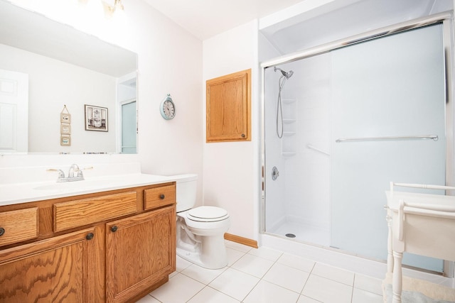 bathroom featuring toilet, a shower with door, vanity, and tile patterned floors