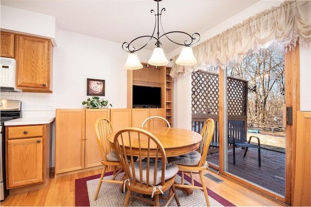 dining space with visible vents and light wood-style flooring