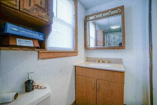 bathroom featuring curtained shower, toilet, tile walls, and vanity