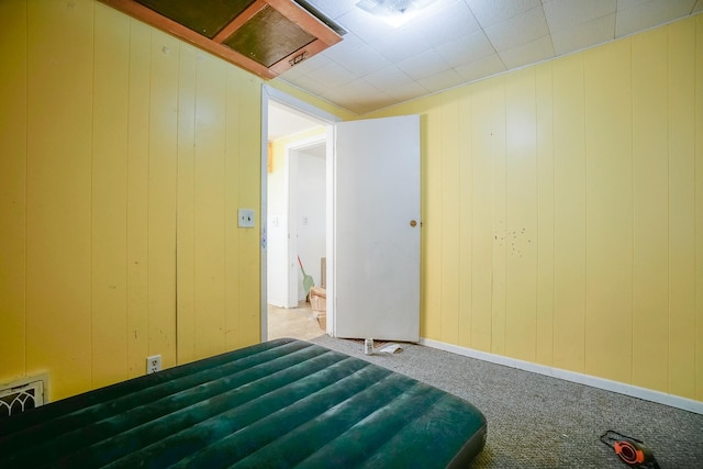 unfurnished bedroom with visible vents, attic access, and carpet floors