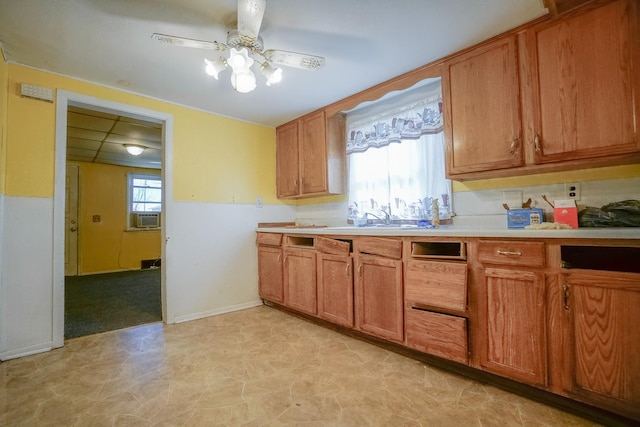 kitchen with light countertops, plenty of natural light, a ceiling fan, and brown cabinets