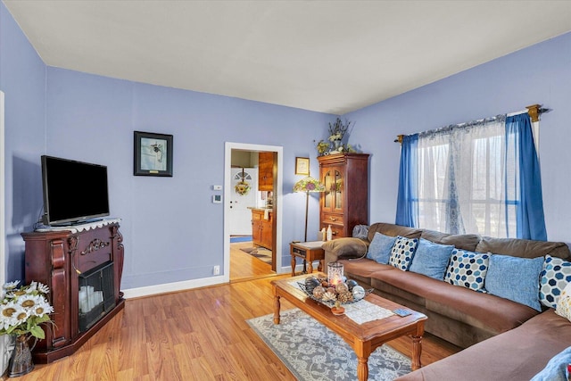 living room with baseboards and light wood-type flooring