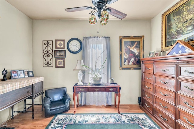 sitting room with a ceiling fan and wood finished floors