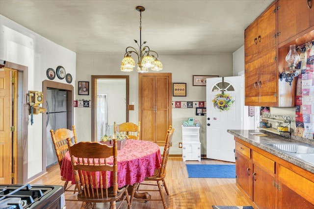 dining space with an inviting chandelier and light wood-style flooring