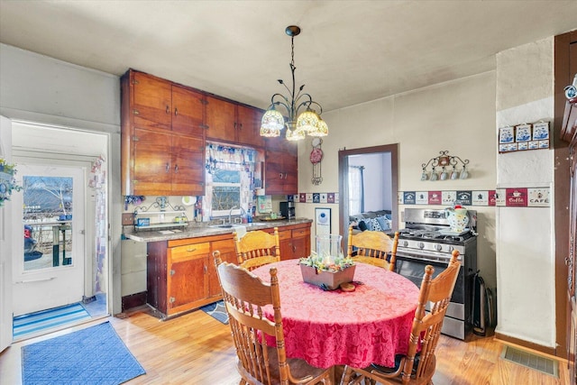 dining space featuring a chandelier, visible vents, and light wood-type flooring