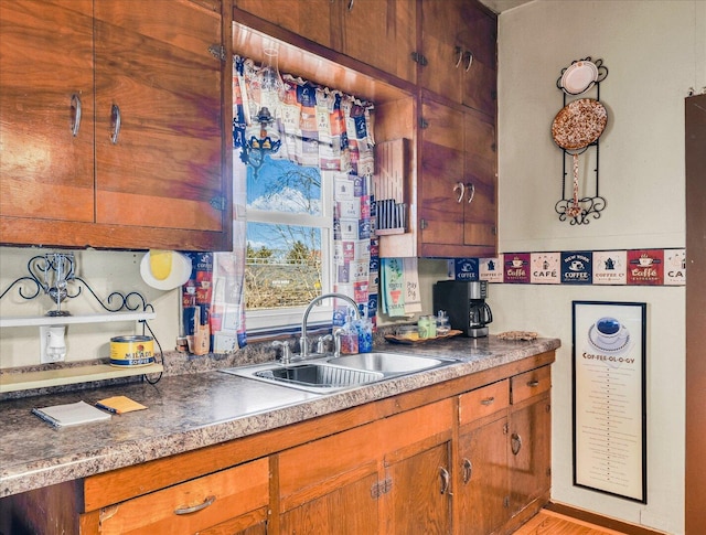 kitchen featuring brown cabinetry and a sink