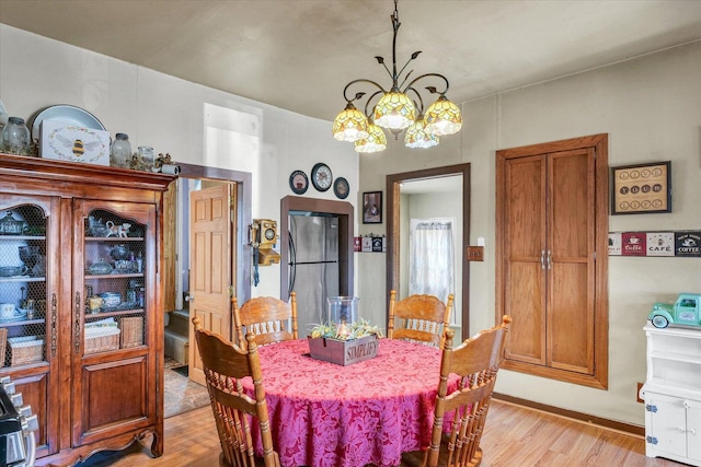 dining space featuring a chandelier and light wood finished floors