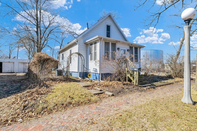 view of front of house with central AC unit and a sunroom