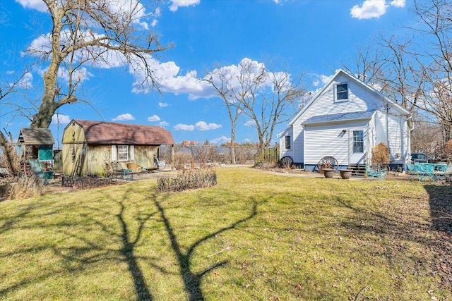 view of yard featuring an outbuilding, entry steps, and fence