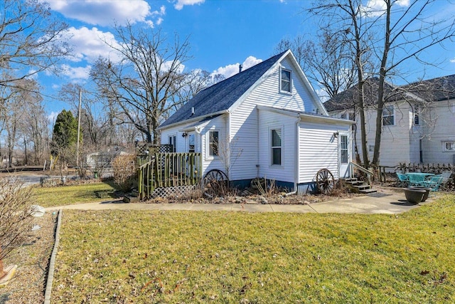 back of house featuring entry steps and a yard