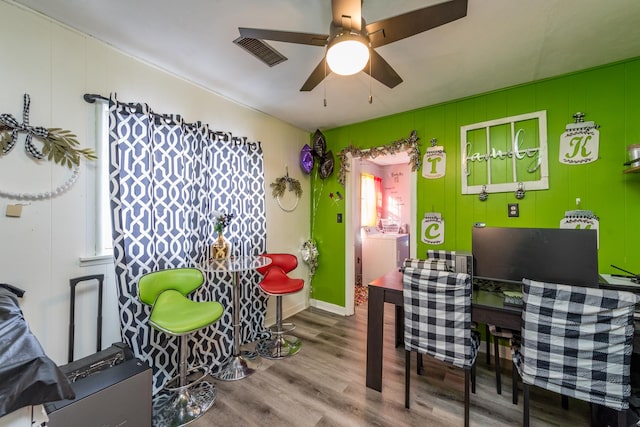 recreation room with visible vents, a ceiling fan, wood finished floors, washer / dryer, and baseboards