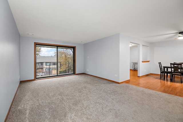 carpeted spare room with a ceiling fan, visible vents, and baseboards