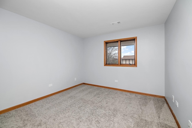 carpeted spare room with visible vents and baseboards