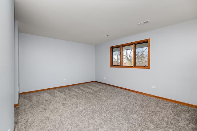 empty room featuring carpet, visible vents, and baseboards