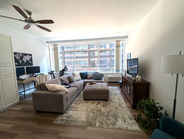 living area with a wall unit AC, wood finished floors, and a ceiling fan