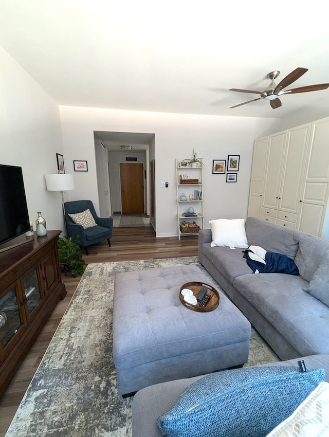 living area with a ceiling fan and wood finished floors