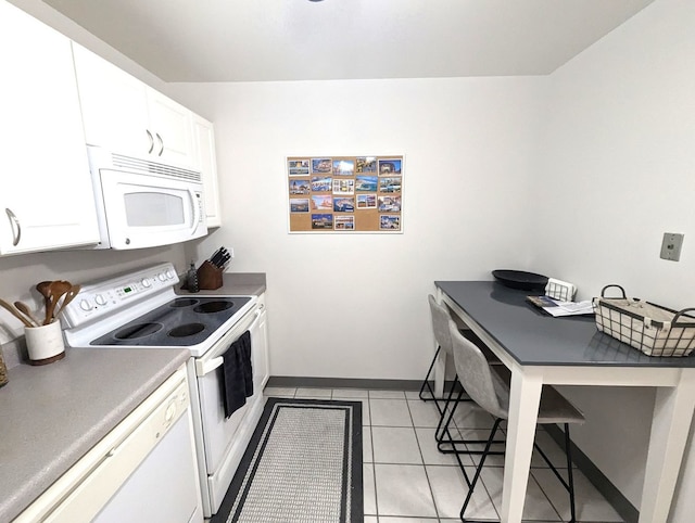 kitchen with white appliances, white cabinets, baseboards, and light tile patterned floors