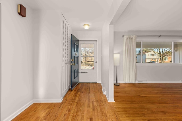 corridor featuring baseboards and wood finished floors