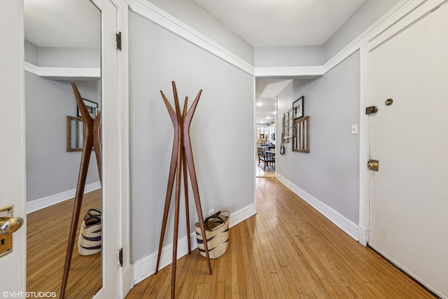 hall featuring baseboards and wood-type flooring