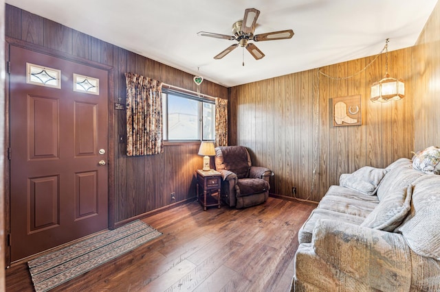 entrance foyer featuring hardwood / wood-style flooring, ceiling fan, baseboards, and wood walls